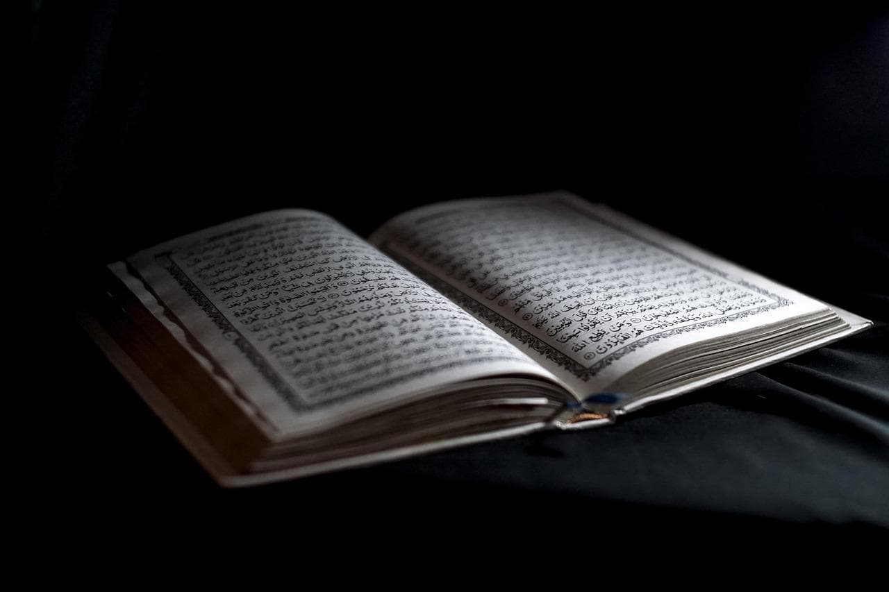 An open Quran illuminated in soft light